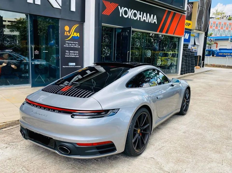 Rear three-quarter of a silver Porsche 911 Carrera 4S outside Infratint Singapore
