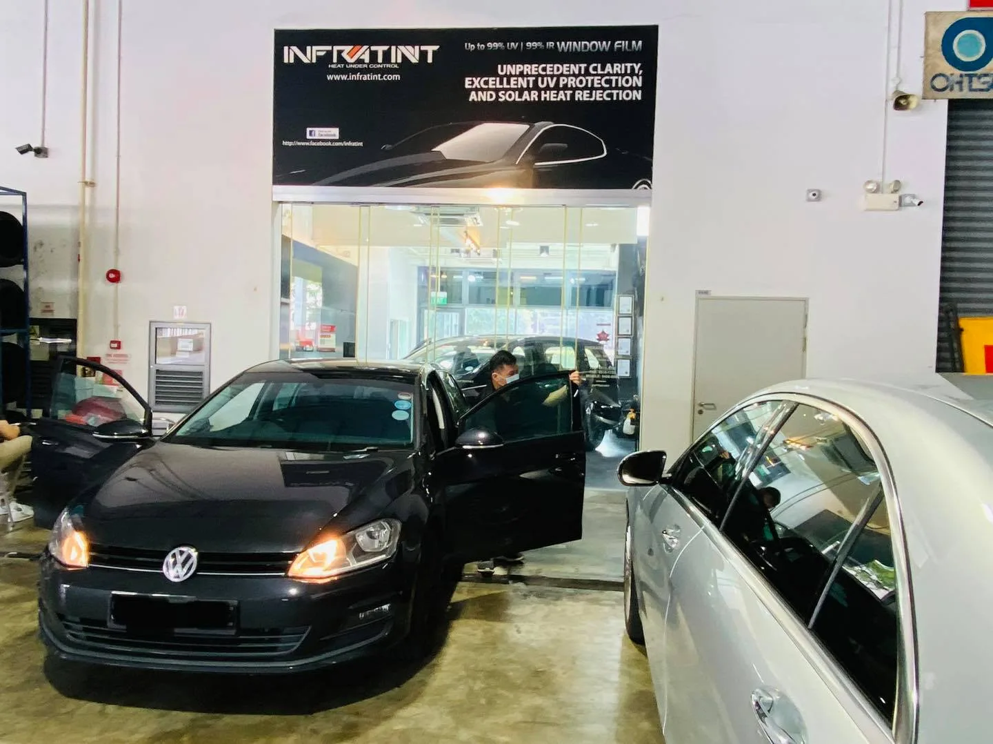Black Volkswagen Golf and silver Mercedes-Benz being tinted at Infratint Singapore