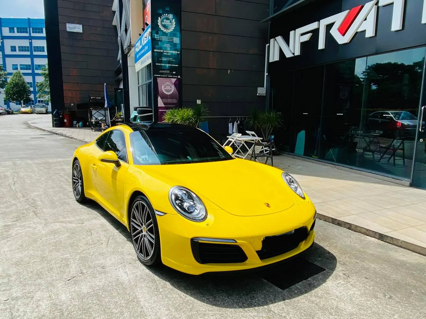 Yellow Porsche 911 outside the Infratint Singapore shopfront after tinting