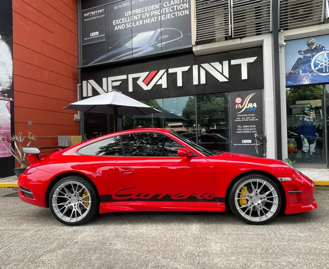 Porsche 911 black and red interior seen through tinted glass at Infratint Singapore