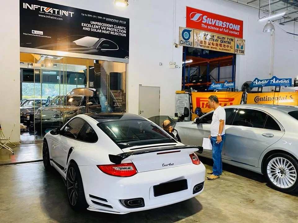 White Porsche 911 Turbo and silver Mercedes-Benz sedan at Infratint Singapore