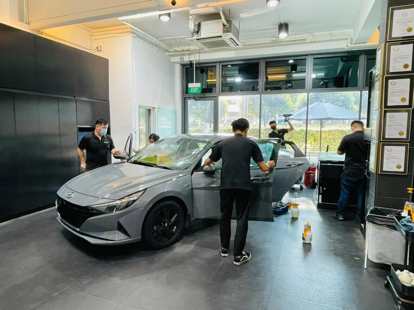 Installer applying window film to a grey Hyundai Avante at Infratint Singapore