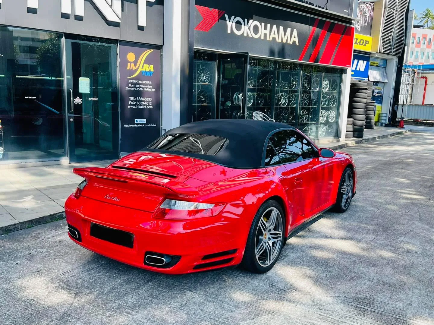 Rear view of a red Porsche 911 Turbo cabriolet outside Infratint Singapore