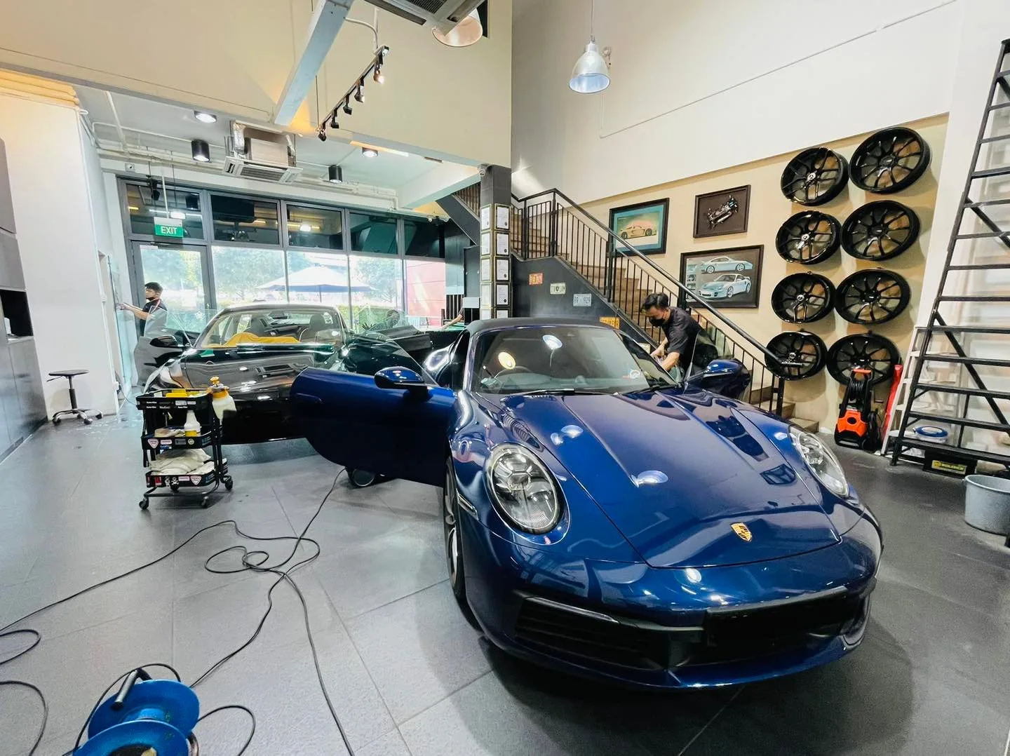 Blue Porsche 911 Carrera at Infratint Singapore for window film, alloy wheel display behind