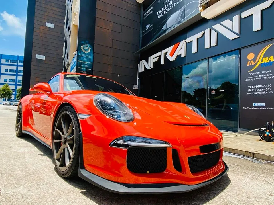 Low front three-quarter view of an orange Porsche 911 GT3 at Infratint Singapore