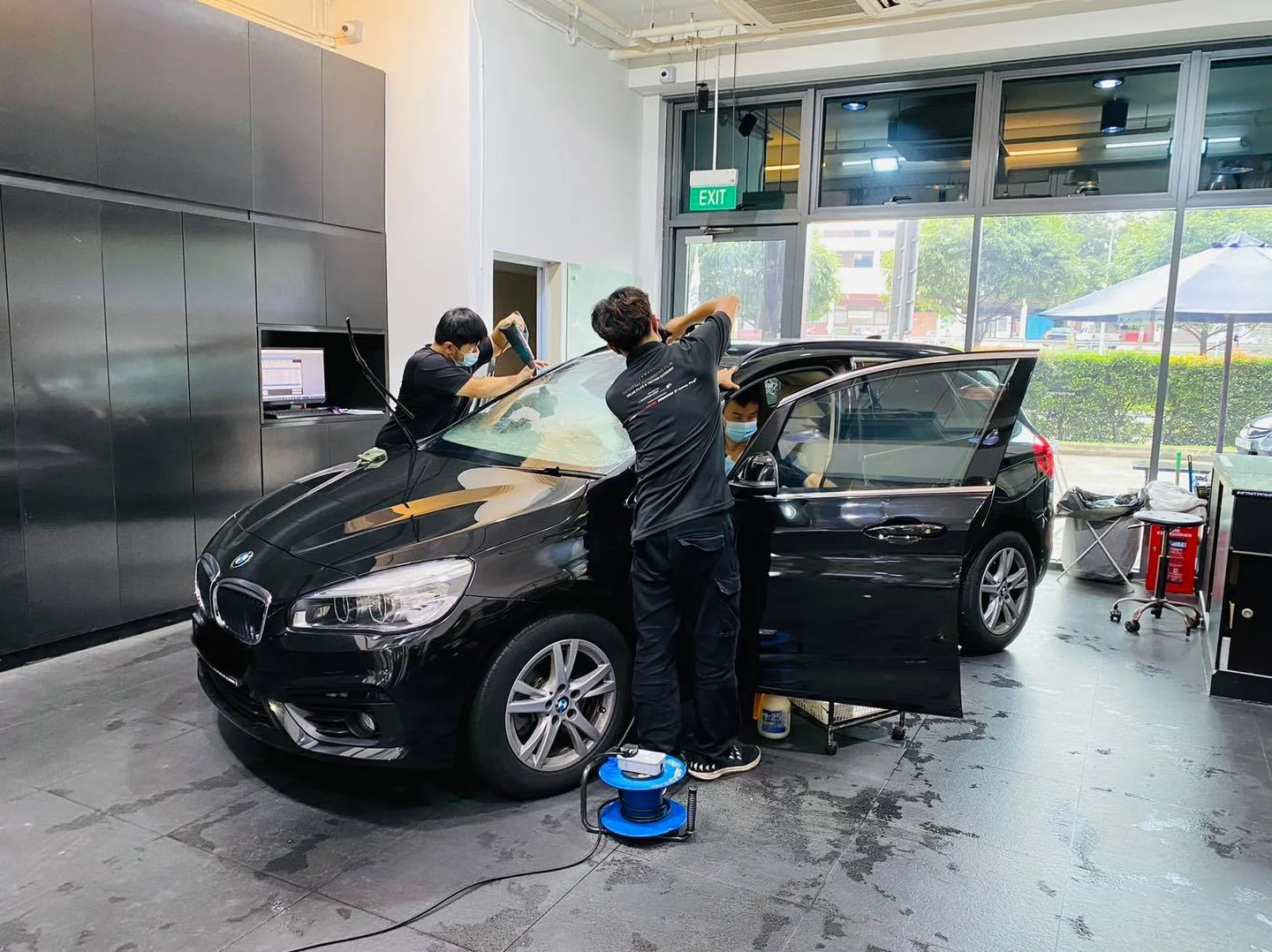 Black BMW 2 Series tourer side view during window tinting at Infratint Singapore