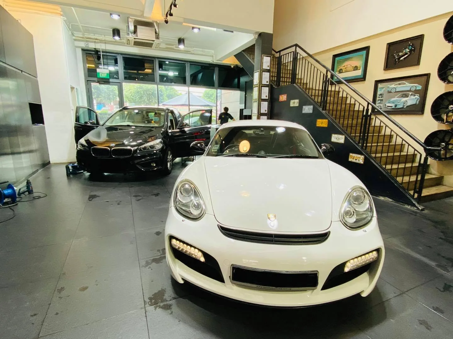 White Porsche coupe and black Honda hatch inside the Infratint Singapore showroom