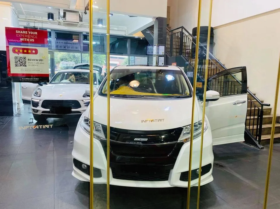 White Honda Odyssey and white Porsche Macan inside Infratint Singapore for window film