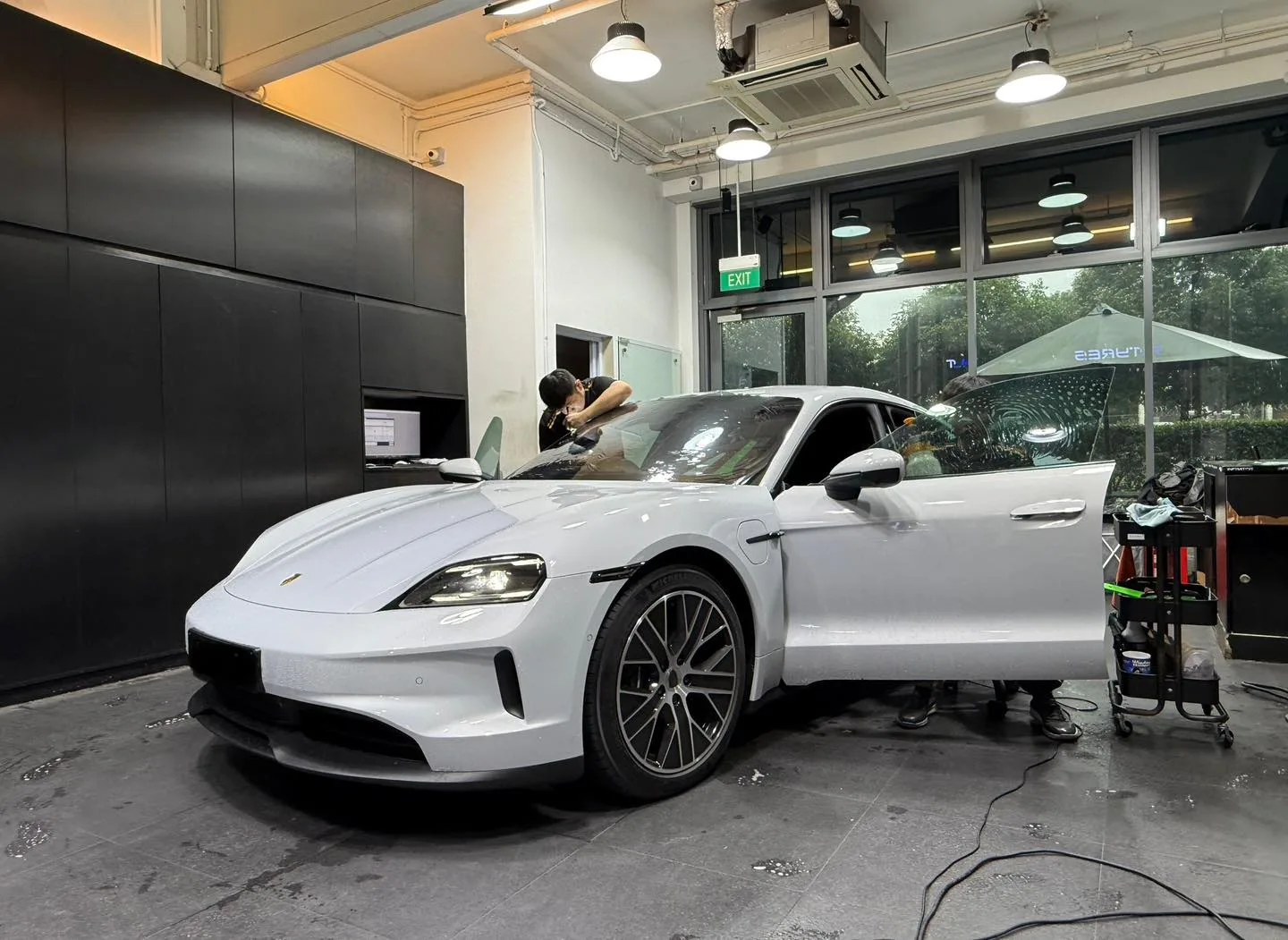 Porsche Taycan front three-quarter inside Infratint Singapore workshop during Platinum99 install