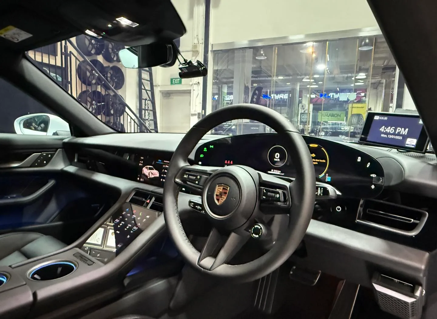 Porsche Taycan steering wheel and digital cluster seen through tinted glass at Infratint Singapore