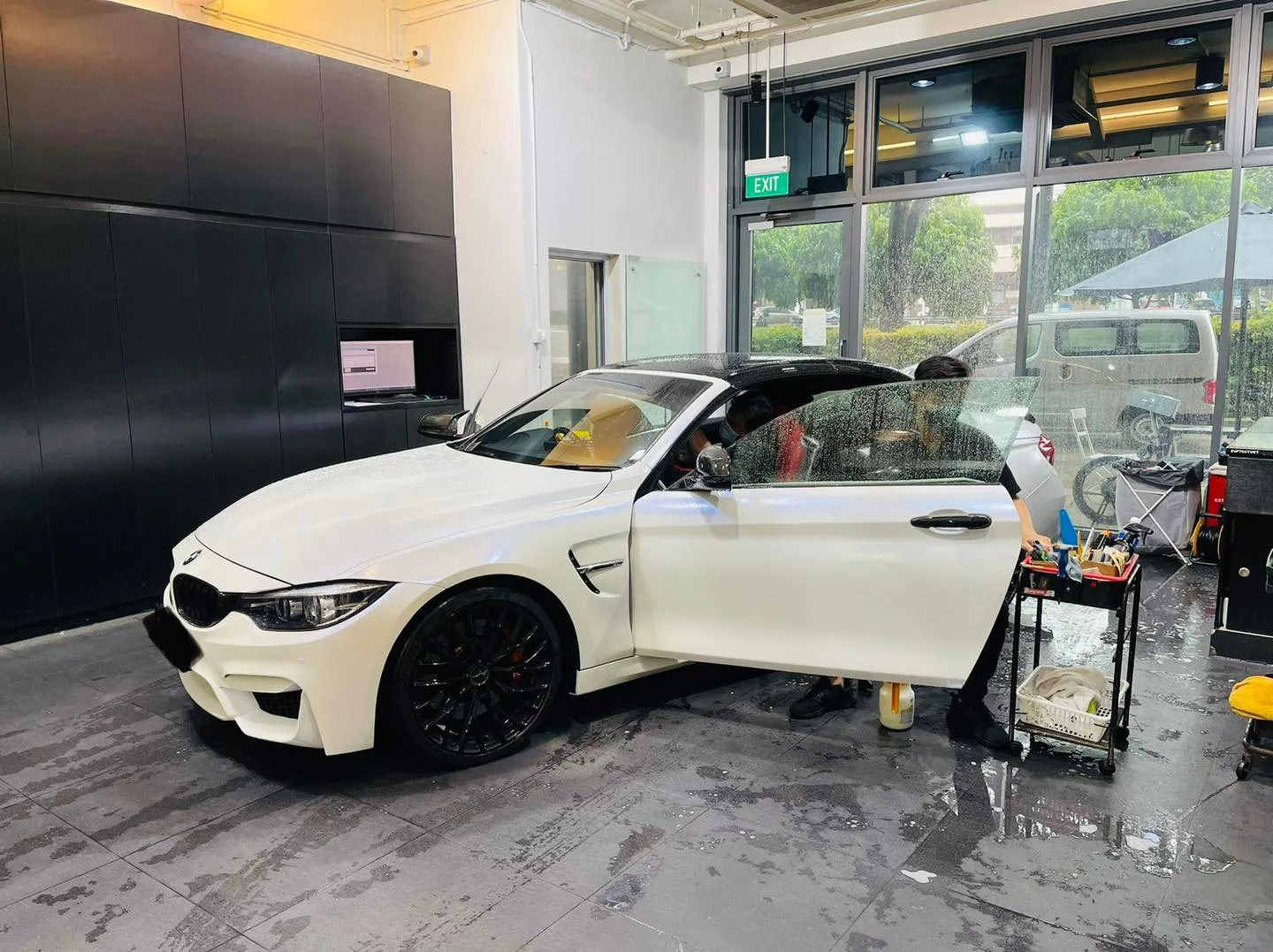 White BMW on black wheels during window tinting at Infratint Singapore