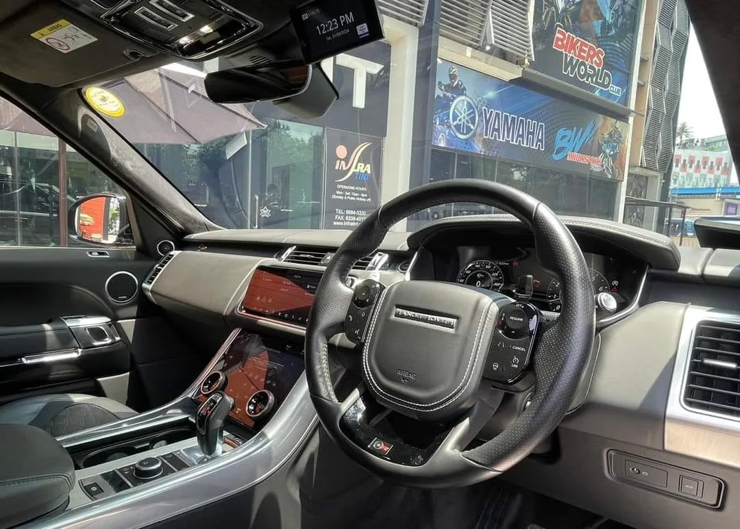 Range Rover SVR interior steering wheel and touchscreens seen through tinted glass at Infratint Singapore