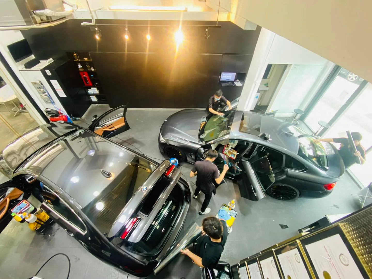 Overhead view of two grey BMW cars being tinted at Infratint Singapore