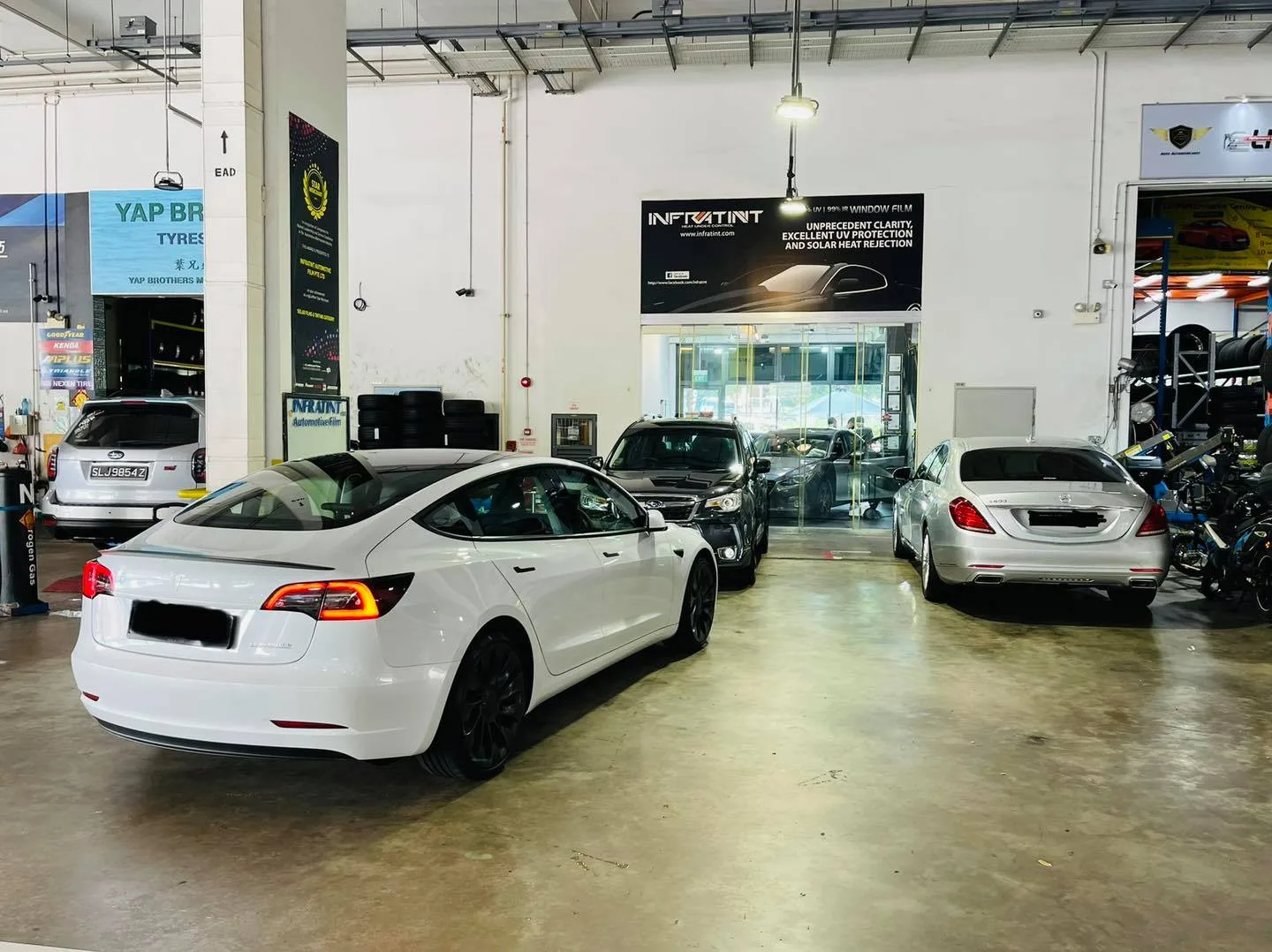 White Tesla and silver Mercedes-Benz at the Infratint Singapore shopfront