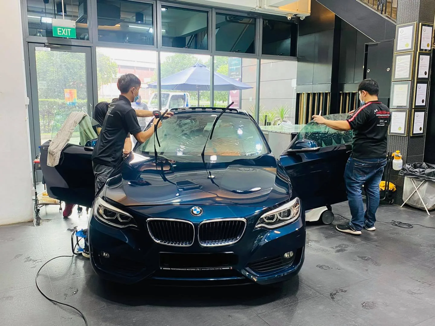 Dark blue BMW 2 Series coupe front view during window film install at Infratint Singapore