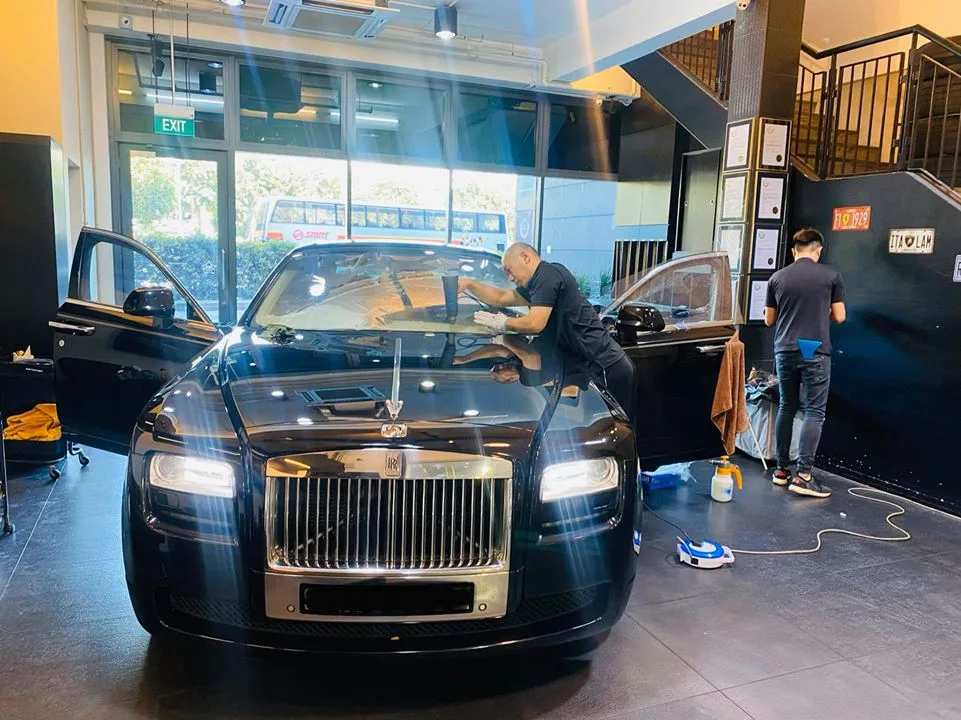 Technician applying windscreen film to a black Rolls-Royce Ghost at Infratint Singapore