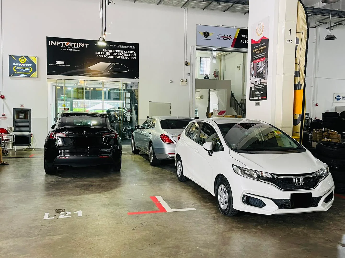 White Honda hatch at Infratint Singapore beneath the banner