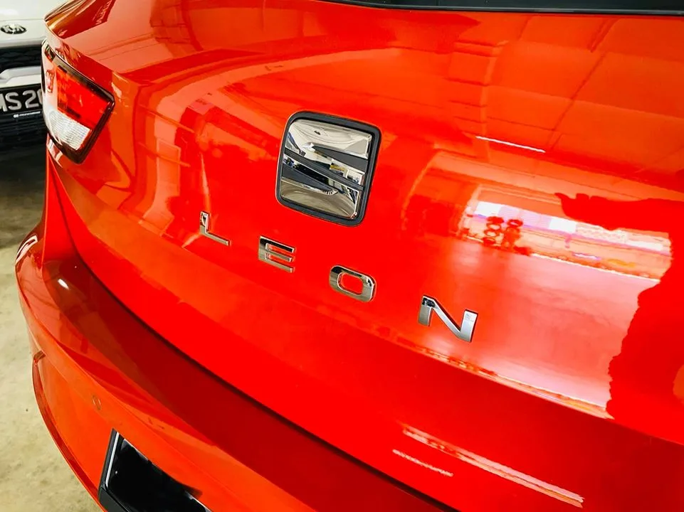 Close-up of the SEAT Leon rear badge on red paintwork at Infratint Singapore