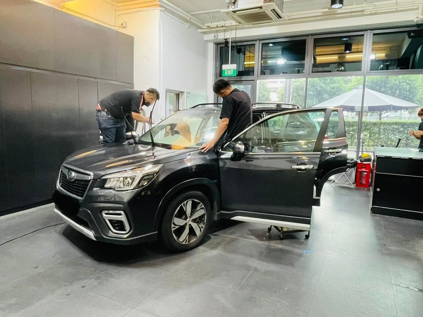 Black Subaru Forester with doors open during window tinting at Infratint Singapore