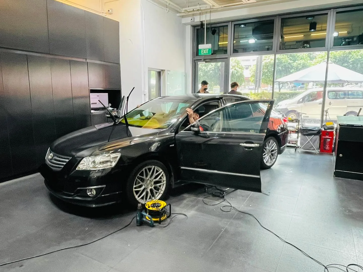 Black Toyota sedan in side profile during window tinting at Infratint Singapore