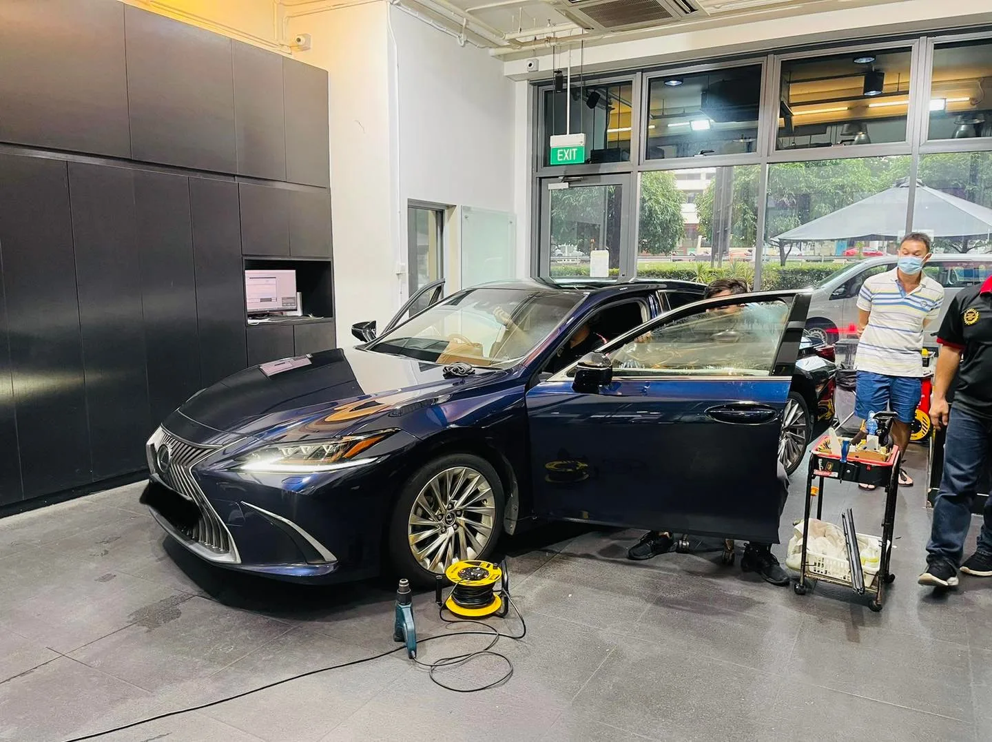 Dark blue Lexus sedan in three-quarter view during window tinting at Infratint Singapore