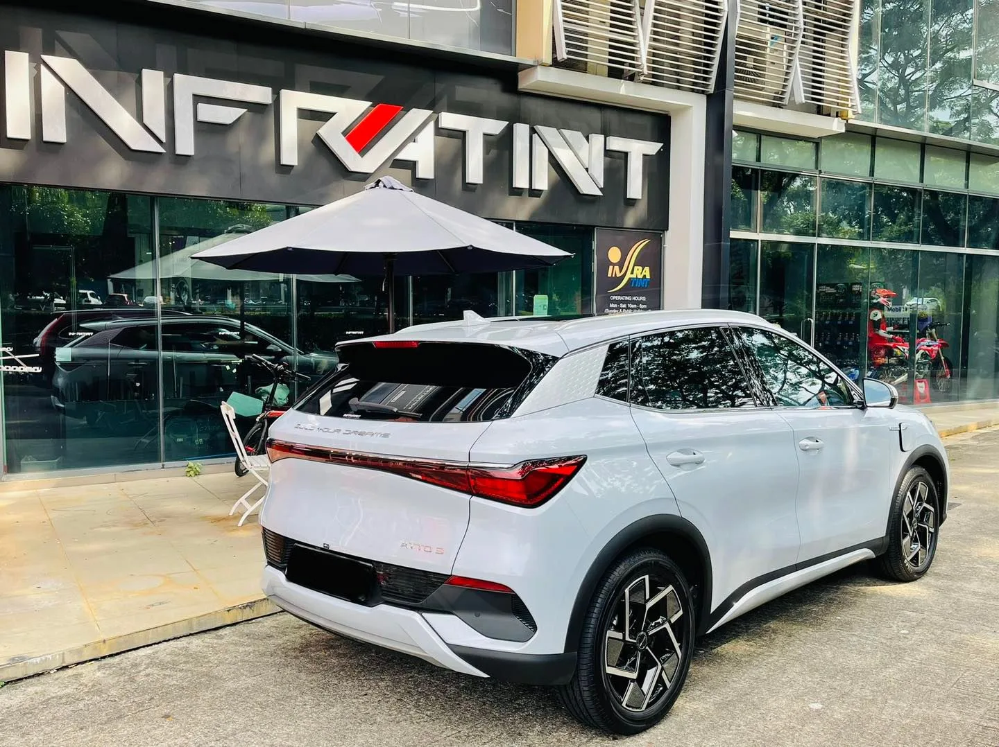 Silver BYD Atto 3 rear view with tailgate open outside Infratint Singapore