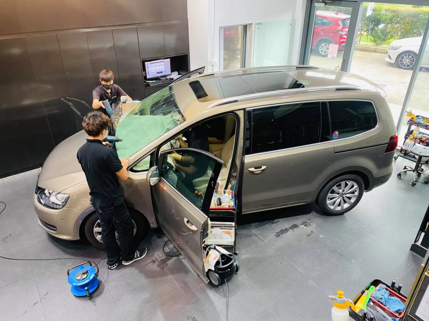 Overhead view of a champagne Volkswagen Sharan MPV being tinted at Infratint Singapore