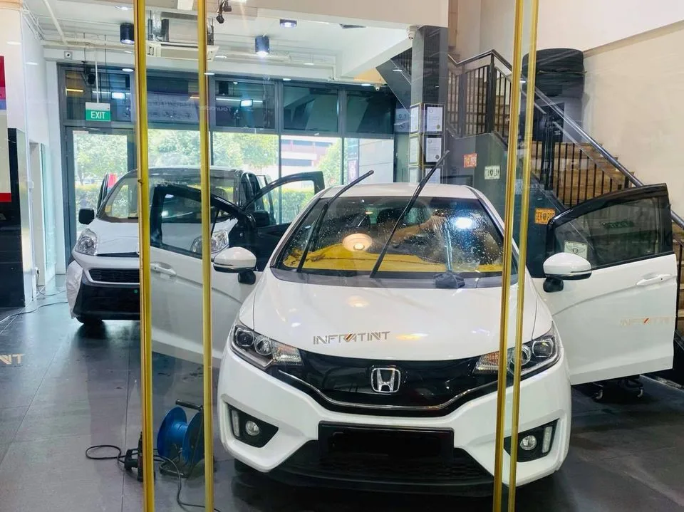 White Honda hatchback with Infratint decal in the showroom at Infratint Singapore
