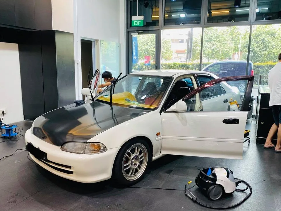 White Honda sedan during window tinting at Infratint Singapore