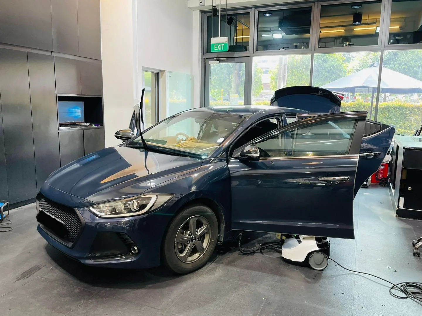 Dark blue Hyundai sedan with boot open during window tinting at Infratint Singapore