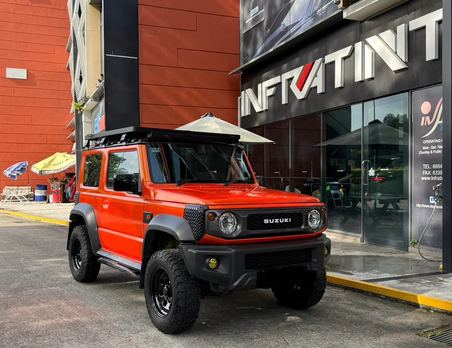 Tinted orange Suzuki Jimny front three-quarter view outside Infratint Singapore