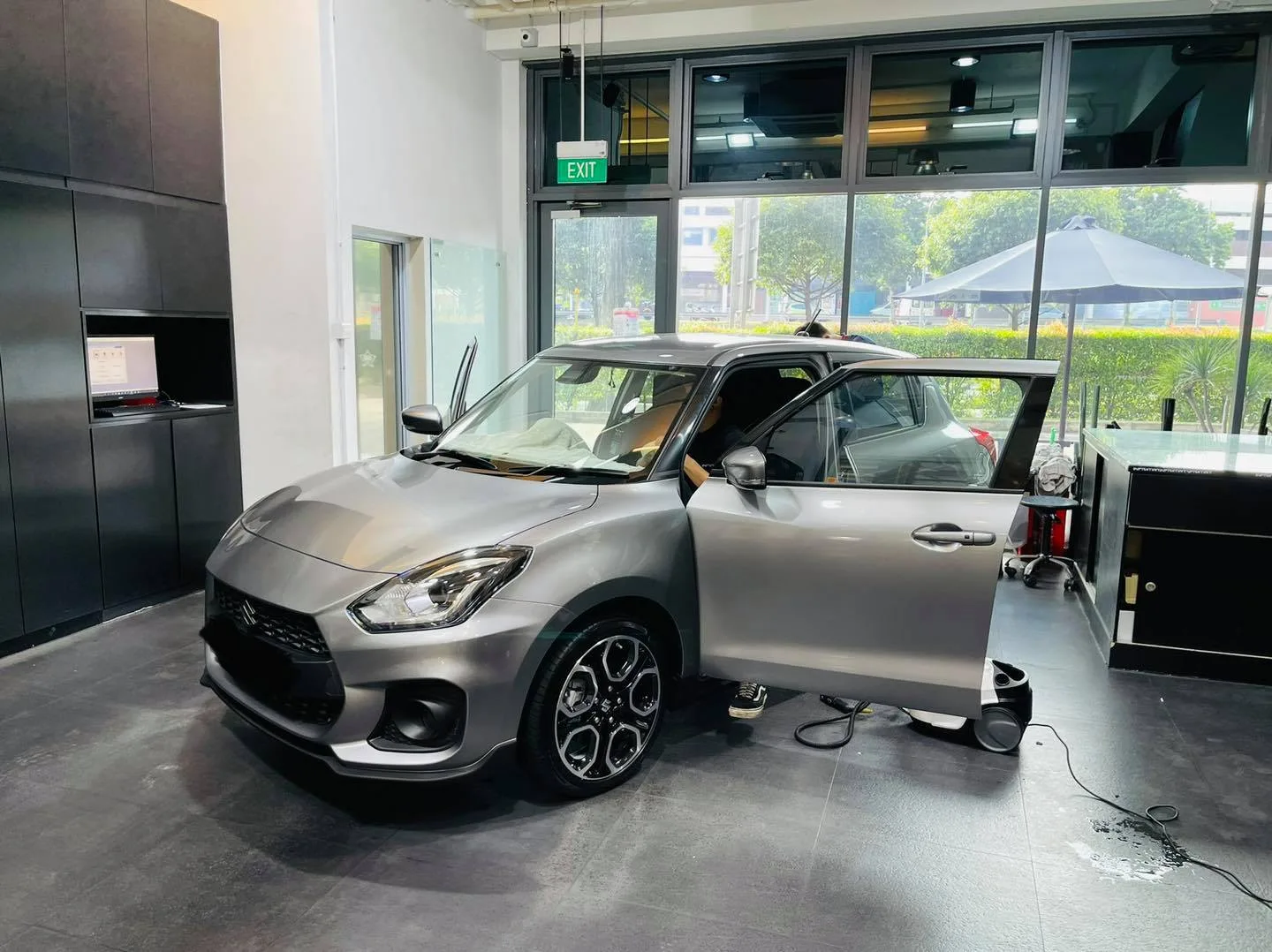 Grey Suzuki Swift with doors open being prepped for solar film at Infratint Singapore