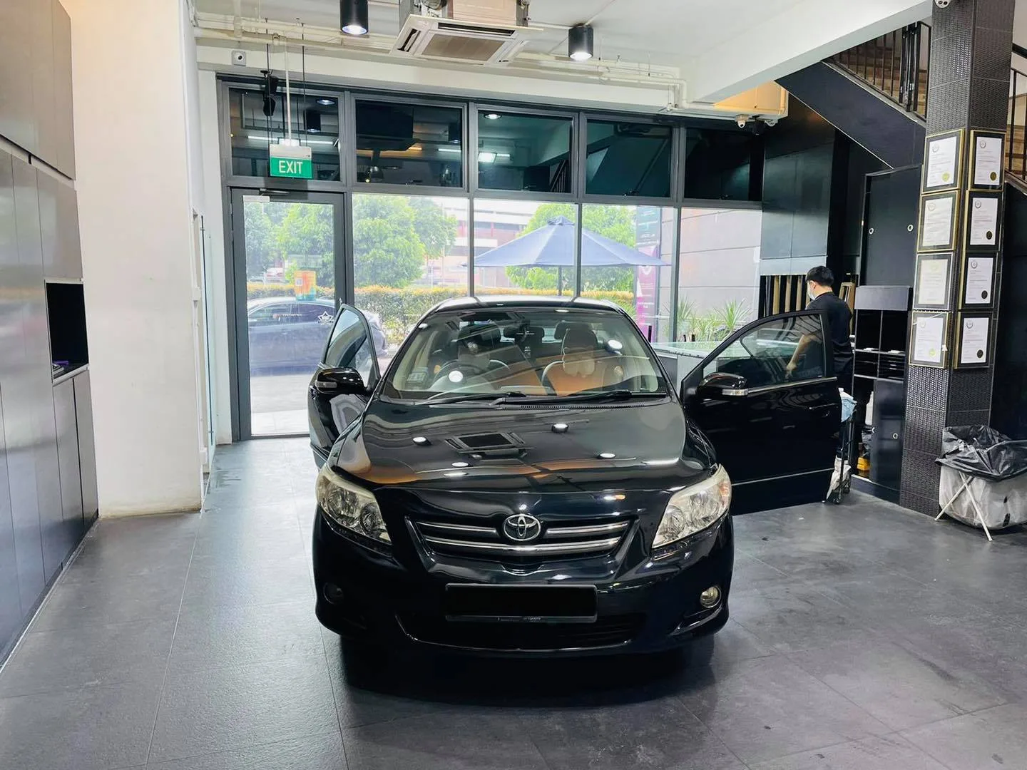 Black Toyota sedan with doors open during window tinting at Infratint Singapore