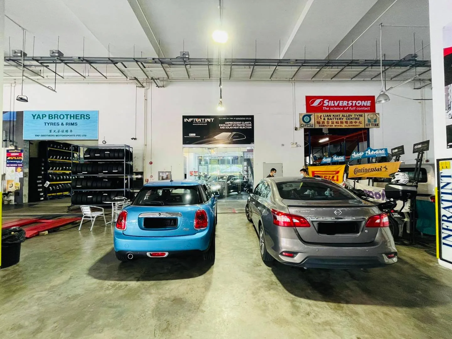 Light blue Mini Cooper and grey Nissan sedan at Infratint Singapore for window tinting