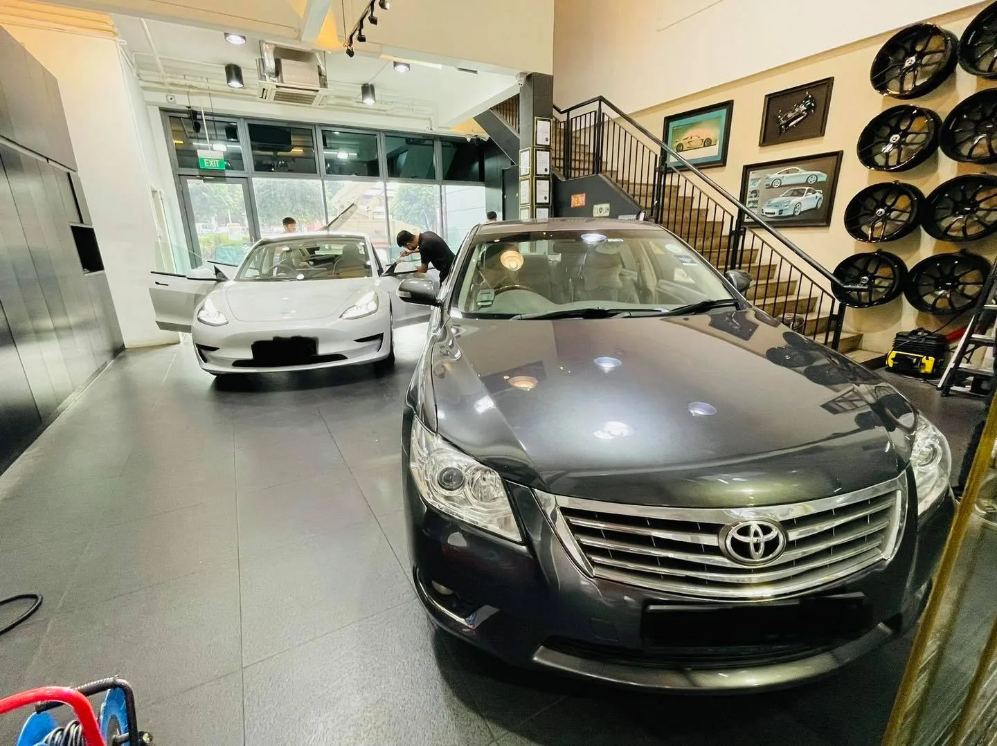 Grey Toyota Camry and white Tesla Model 3 inside the Infratint Singapore showroom for window tinting