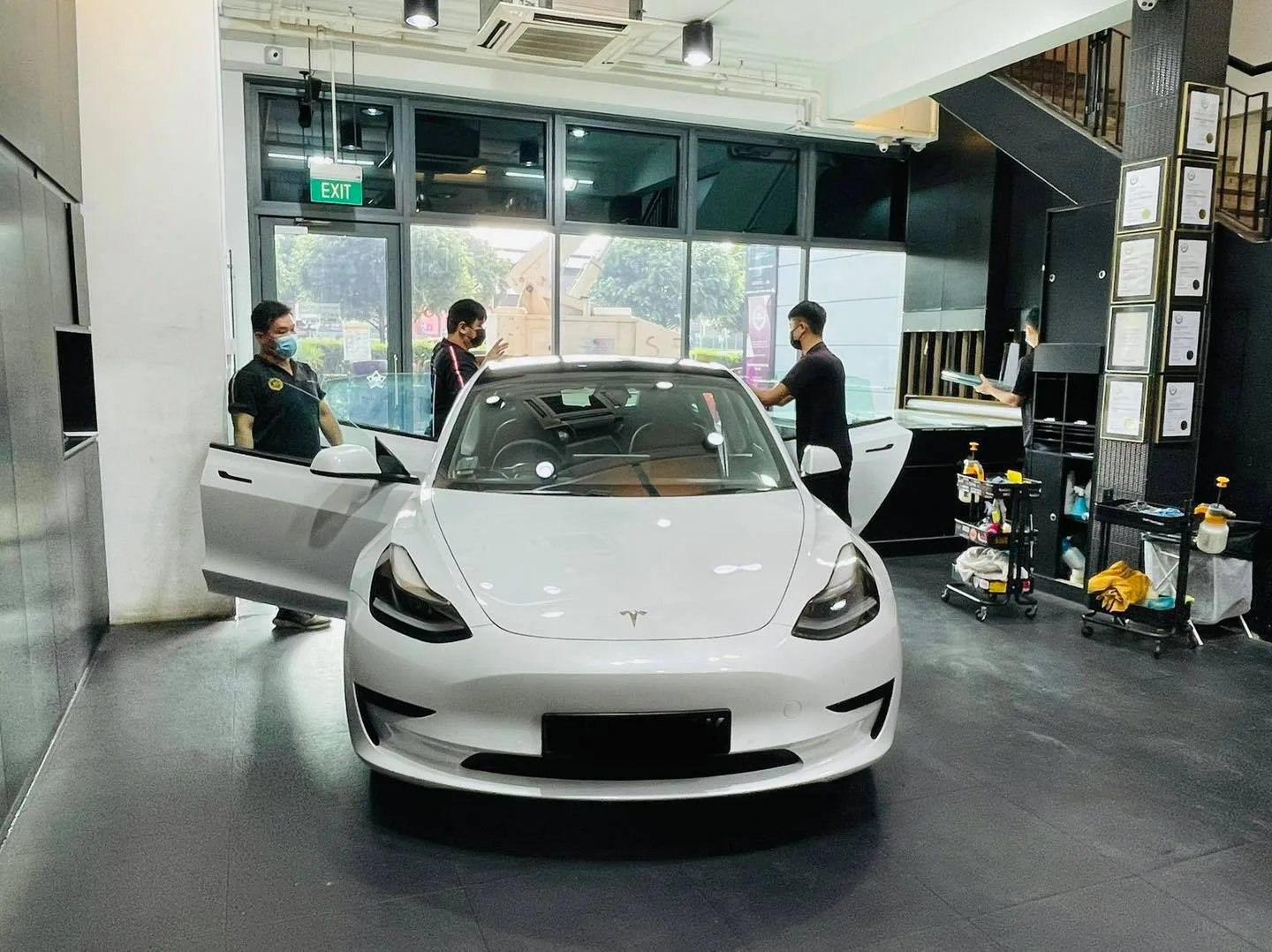 White Tesla Model 3 with door open during window film install at Infratint Singapore