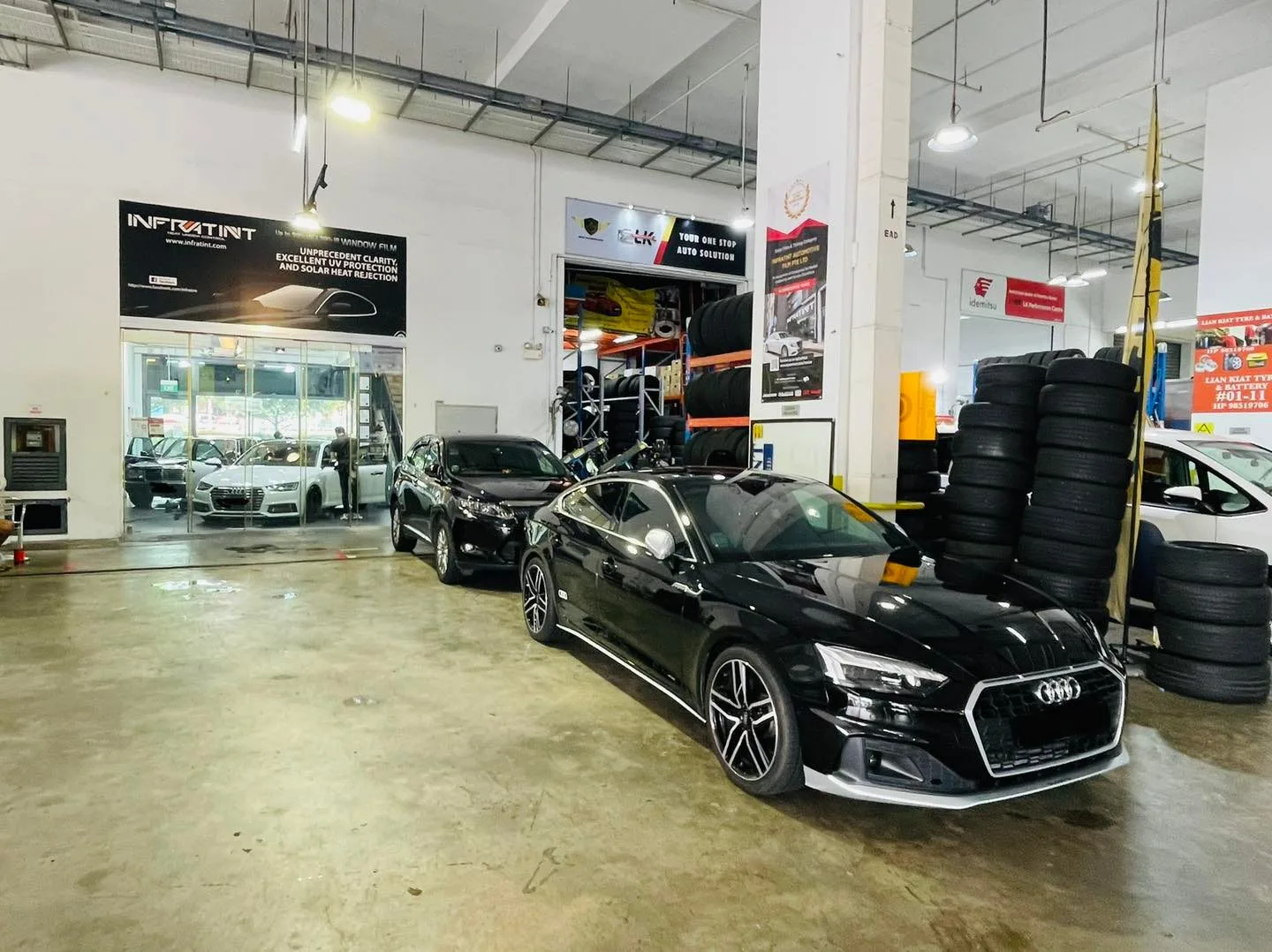 Black Audi coupe parked among tyre stacks at Infratint Singapore