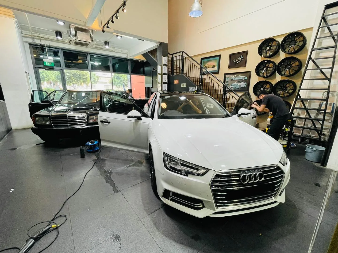 White Audi sedan being tinted next to a vintage Mercedes-Benz at Infratint Singapore