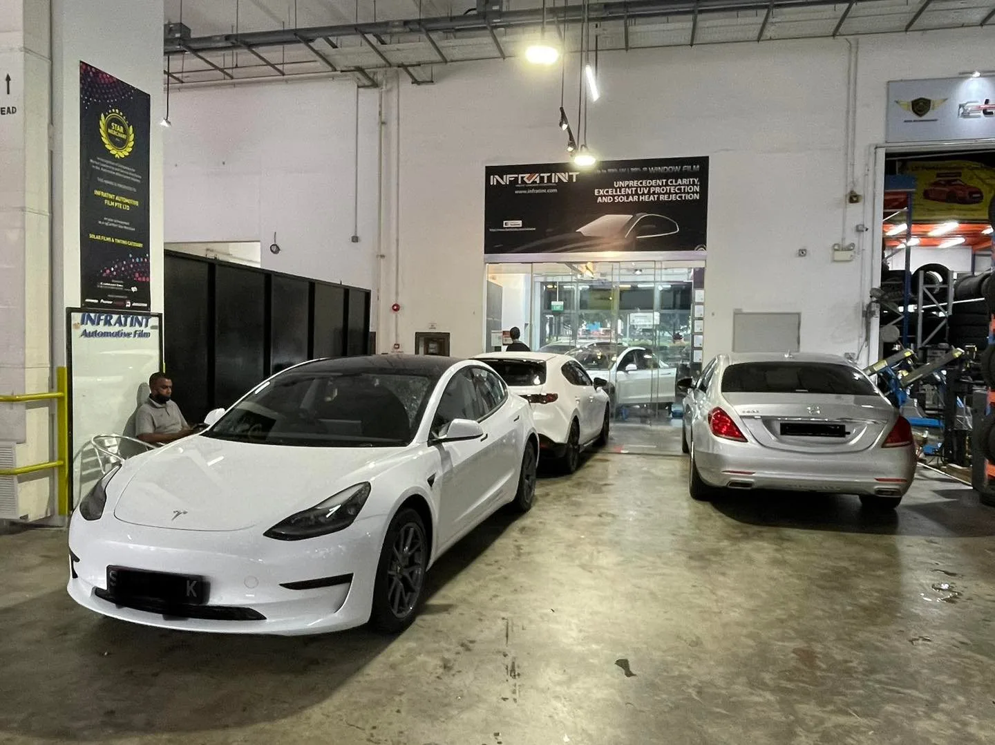 White Tesla Model 3 and silver Mercedes-Benz in the Infratint Singapore install bay
