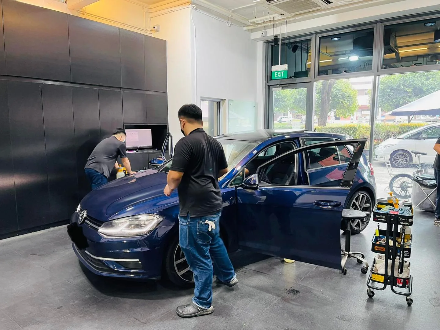 Dark blue Volkswagen Golf during window film installation at Infratint Singapore