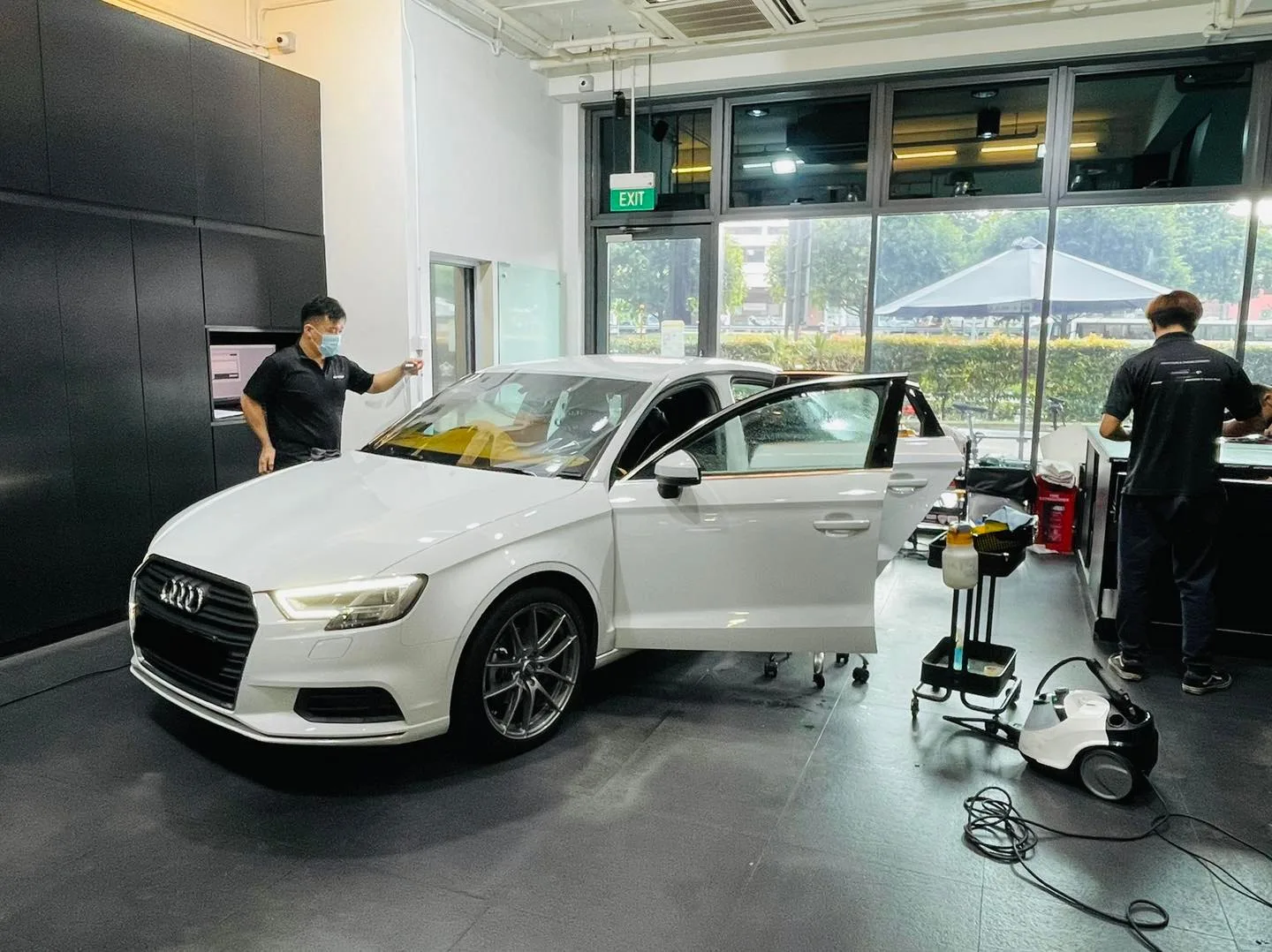 White Audi sedan being tinted by two technicians at Infratint Singapore