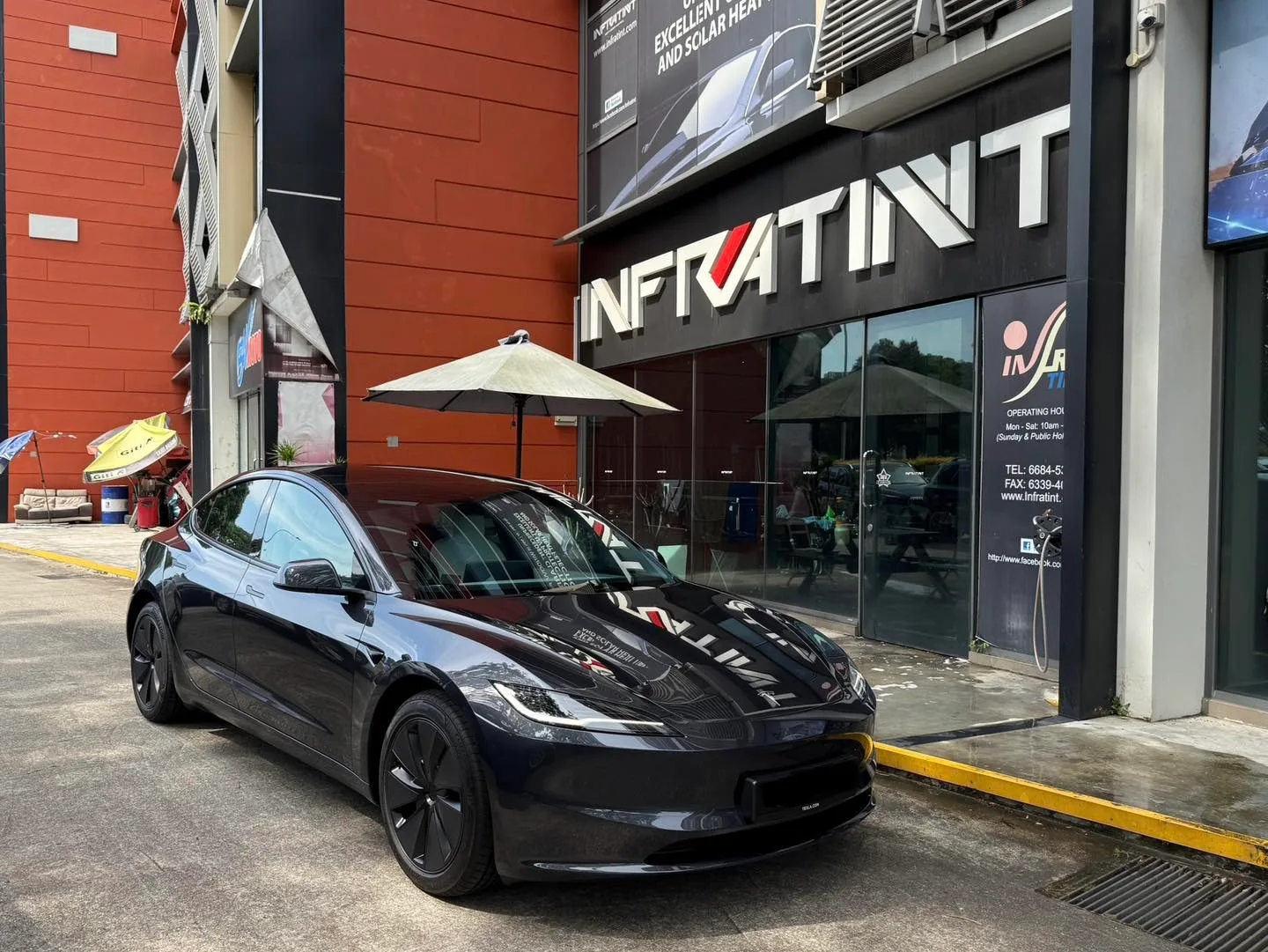 Dark Tesla Model 3 Highland front three-quarter view with tinted windows at Infratint Singapore