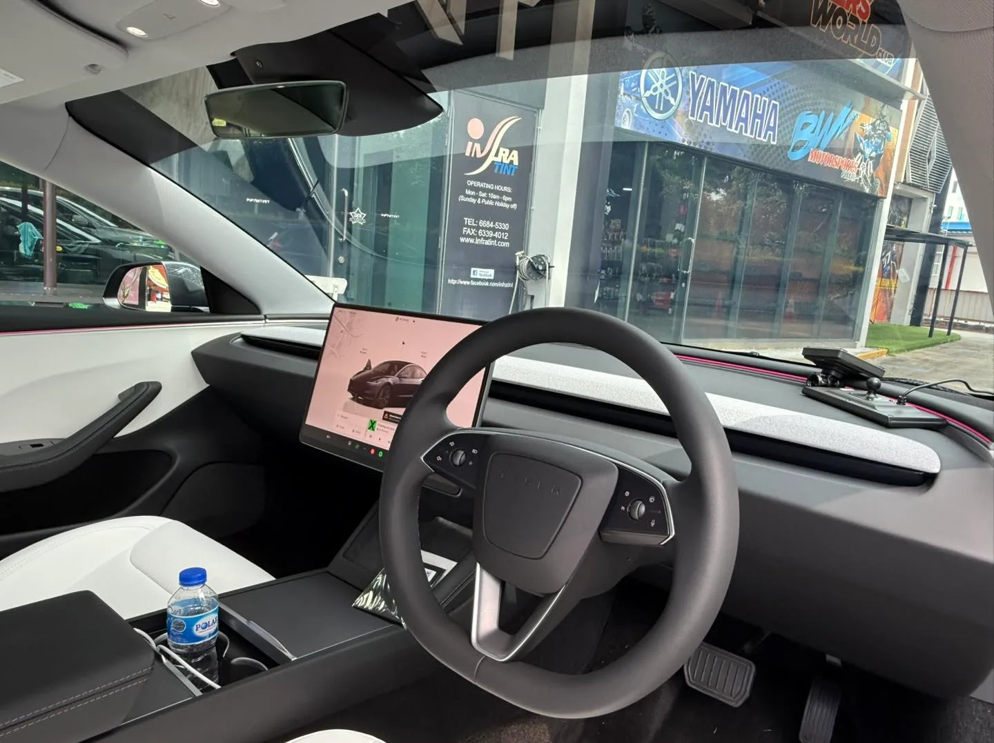 Tesla Model 3 Highland interior with central touchscreen seen through tinted glass at Infratint Singapore