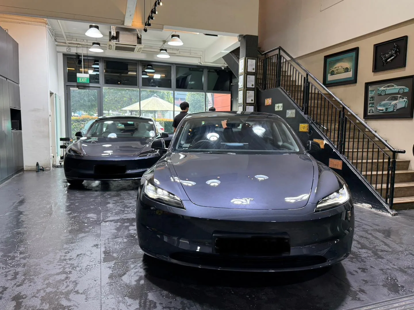 Two Tesla Model 3 Highland cars parked inside the Infratint workshop Singapore