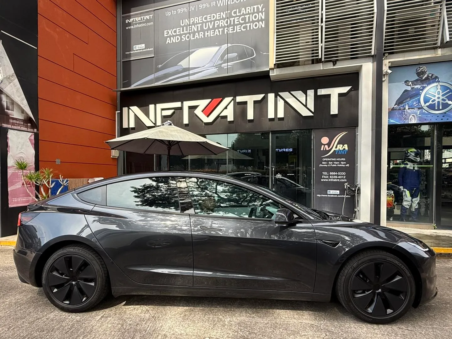 Tesla Model 3 Highland side profile with tinted windows outside Infratint Singapore