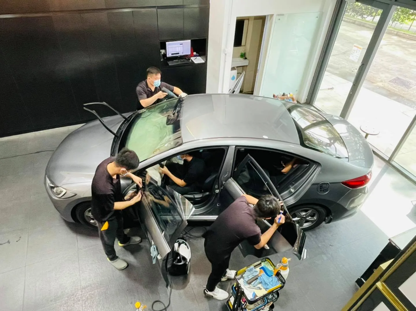 Overhead view of installers tinting a grey Hyundai Elantra at Infratint Singapore