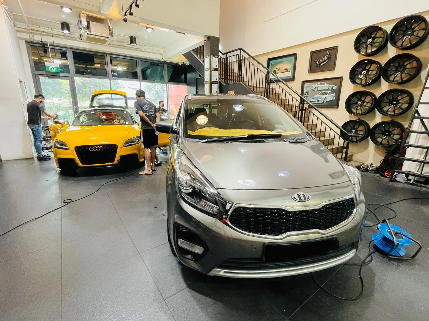 Grey Kia MPV and yellow Audi TT inside the Infratint Singapore showroom for window tinting