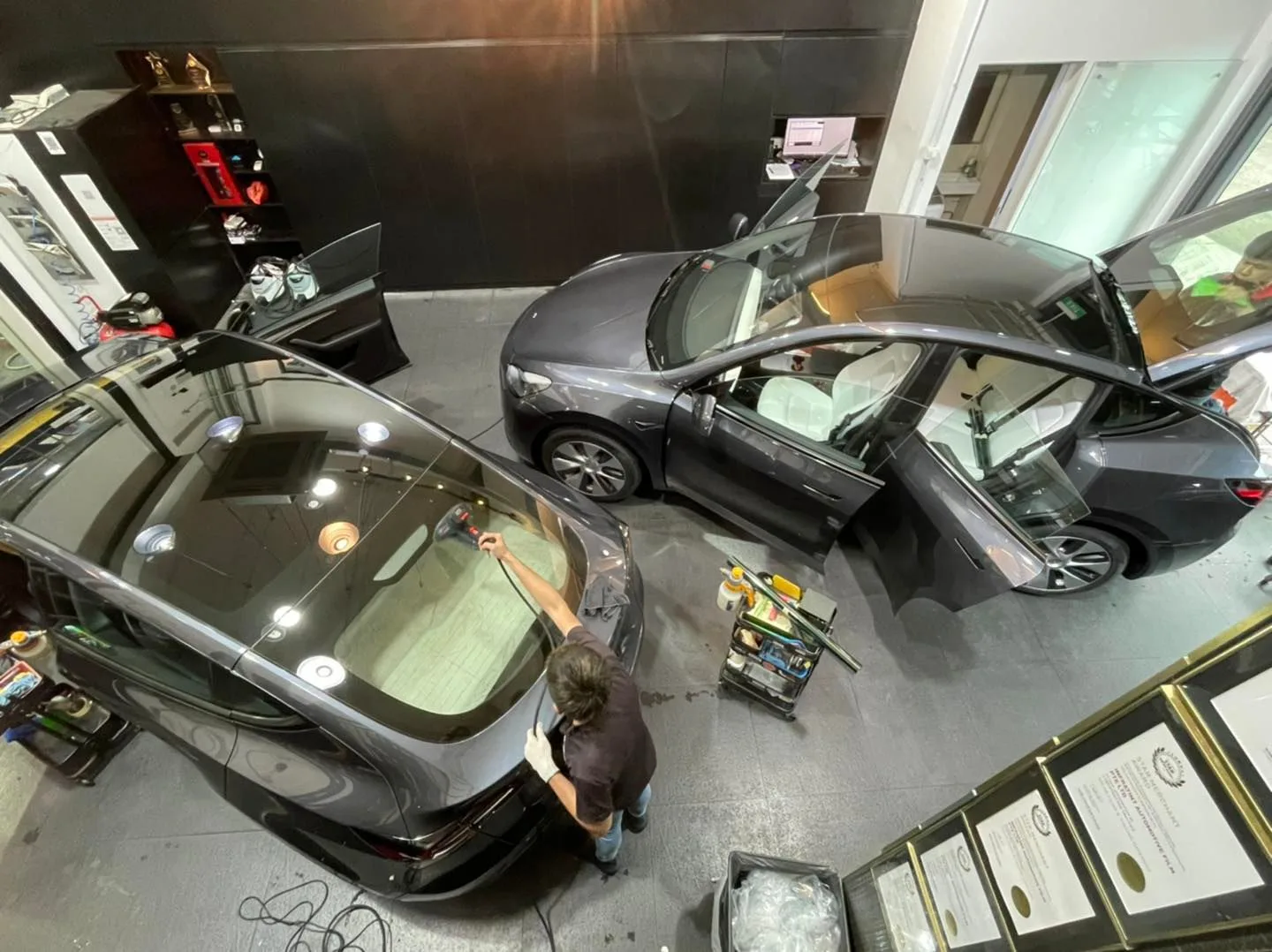 Overhead view of an installer applying window film to a Tesla rear windscreen at Infratint Singapore