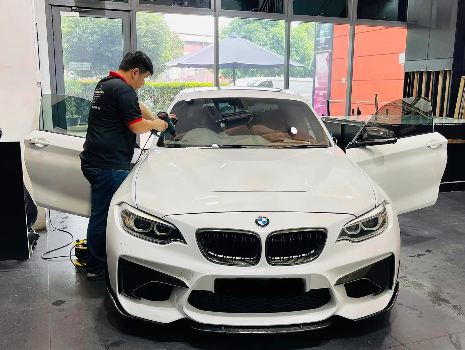 White BMW M2 coupe during window film install at Infratint Singapore