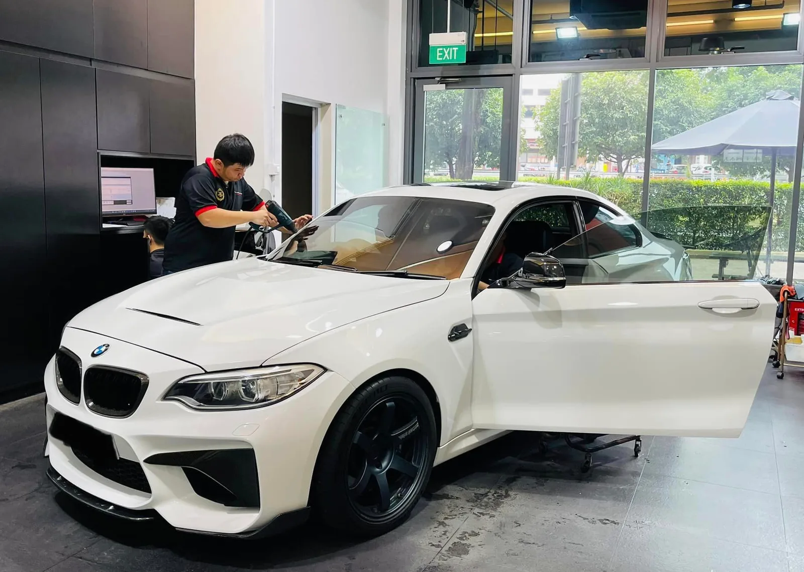 White BMW M2 coupe with doors open being tinted at Infratint Singapore